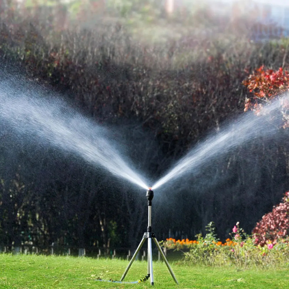 "Automatischer Gartensprinkler mit rotierendem Kopf und einziehbarem Stativ auf grüner Rasenfläche, Gartenbewässerung"
