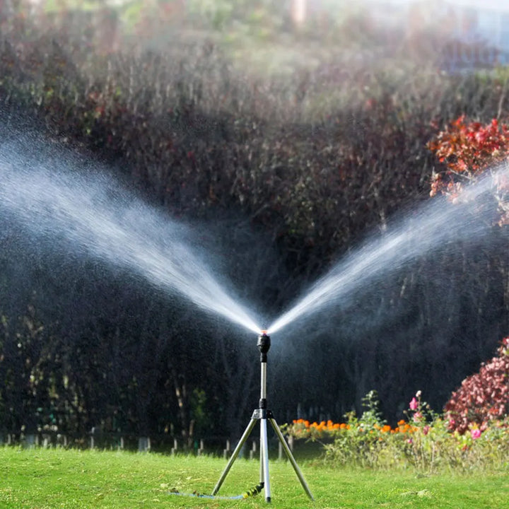 "Automatischer Gartensprinkler mit rotierendem Kopf und einziehbarem Stativ auf grüner Rasenfläche, Gartenbewässerung"