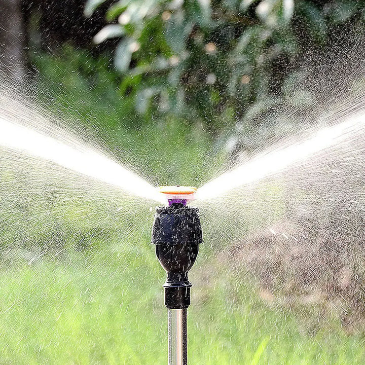 "Automatischer Gartensprinkler mit rotierendem Kopf und einziehbarem Stativ auf grüner Rasenfläche, Gartenbewässerung"