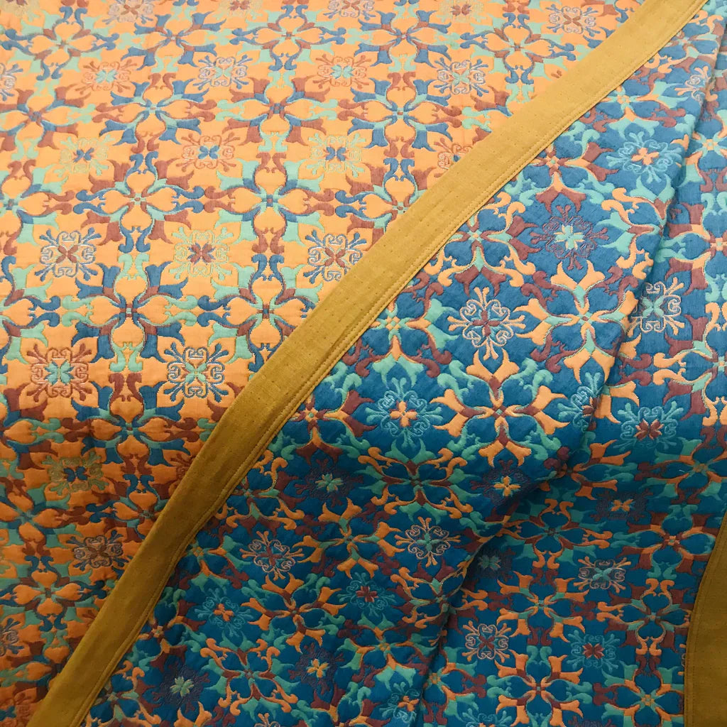 "Blauer Quilt mit sechs Baumwollschichten und kunstvollem Muster für stilvolle Wohnraumgestaltung und angenehme Wärme."