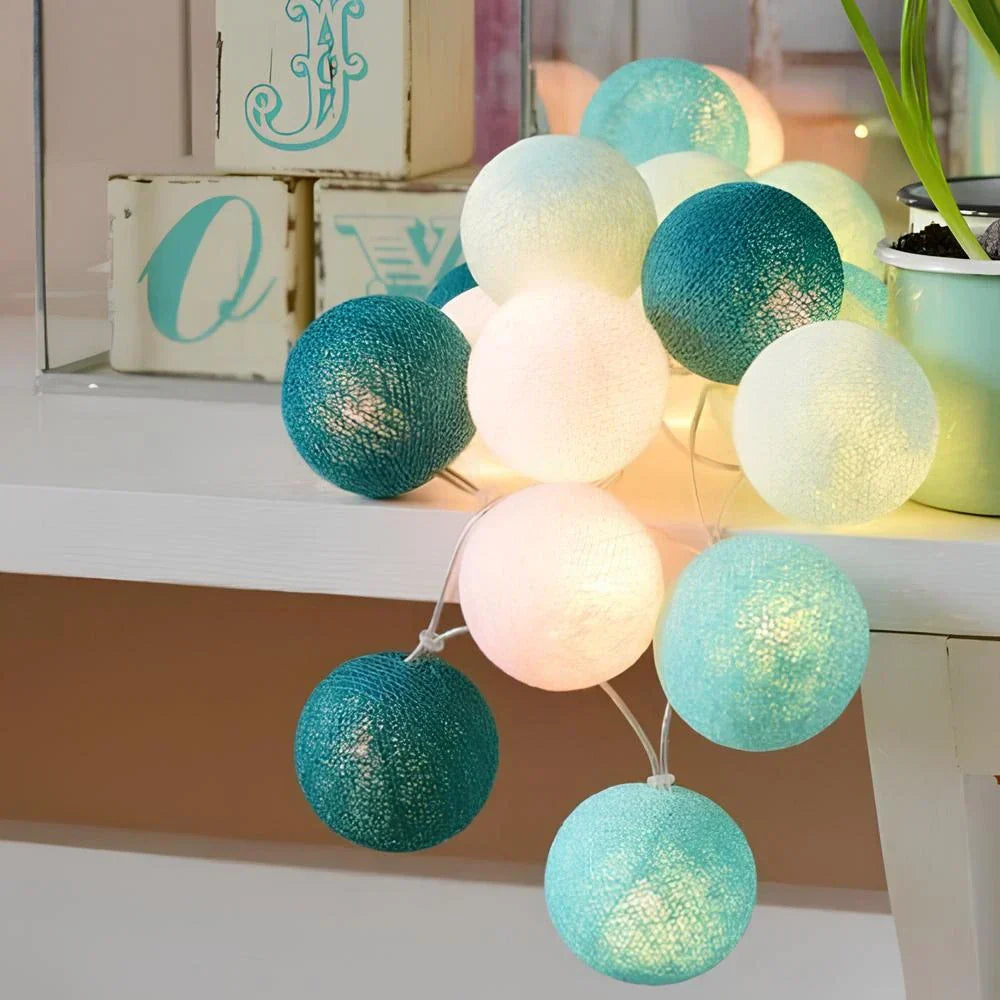 "Bunte LED Lichterkette mit Baumwollkugeln, flexibel und dekorativ, auf Tisch liegend, schafft gemütliche Atmosphäre."