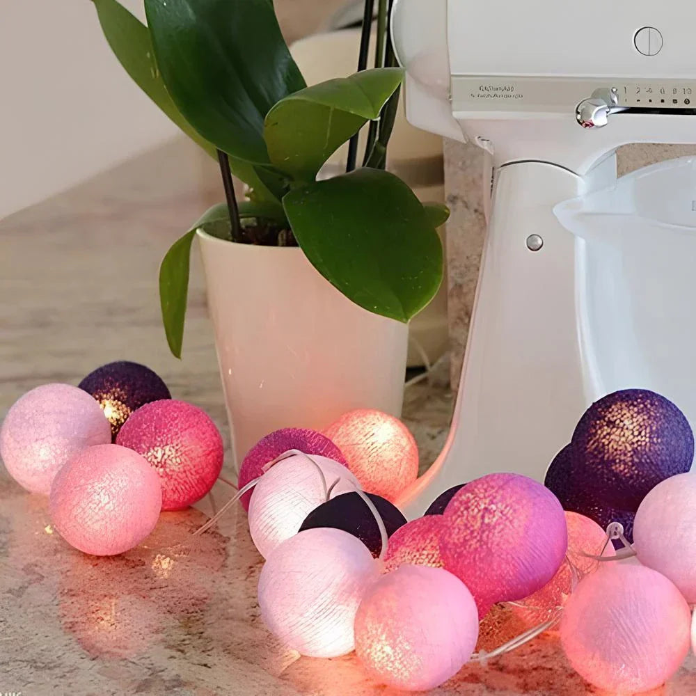 "Bunte LED Lichterkette mit Baumwollkugeln, flexibel und dekorativ, auf Tisch liegend, schafft gemütliche Atmosphäre."