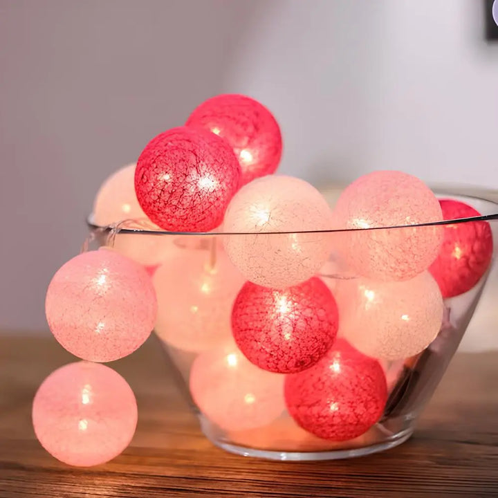 "Bunte LED Lichterkette mit Baumwollkugeln, flexibel und dekorativ, auf Tisch liegend, schafft gemütliche Atmosphäre."