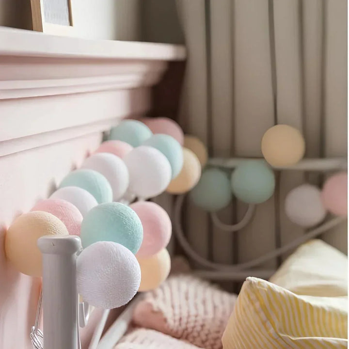 "Bunte LED Lichterkette mit Baumwollkugeln, flexibel und dekorativ, auf Tisch liegend, schafft gemütliche Atmosphäre."