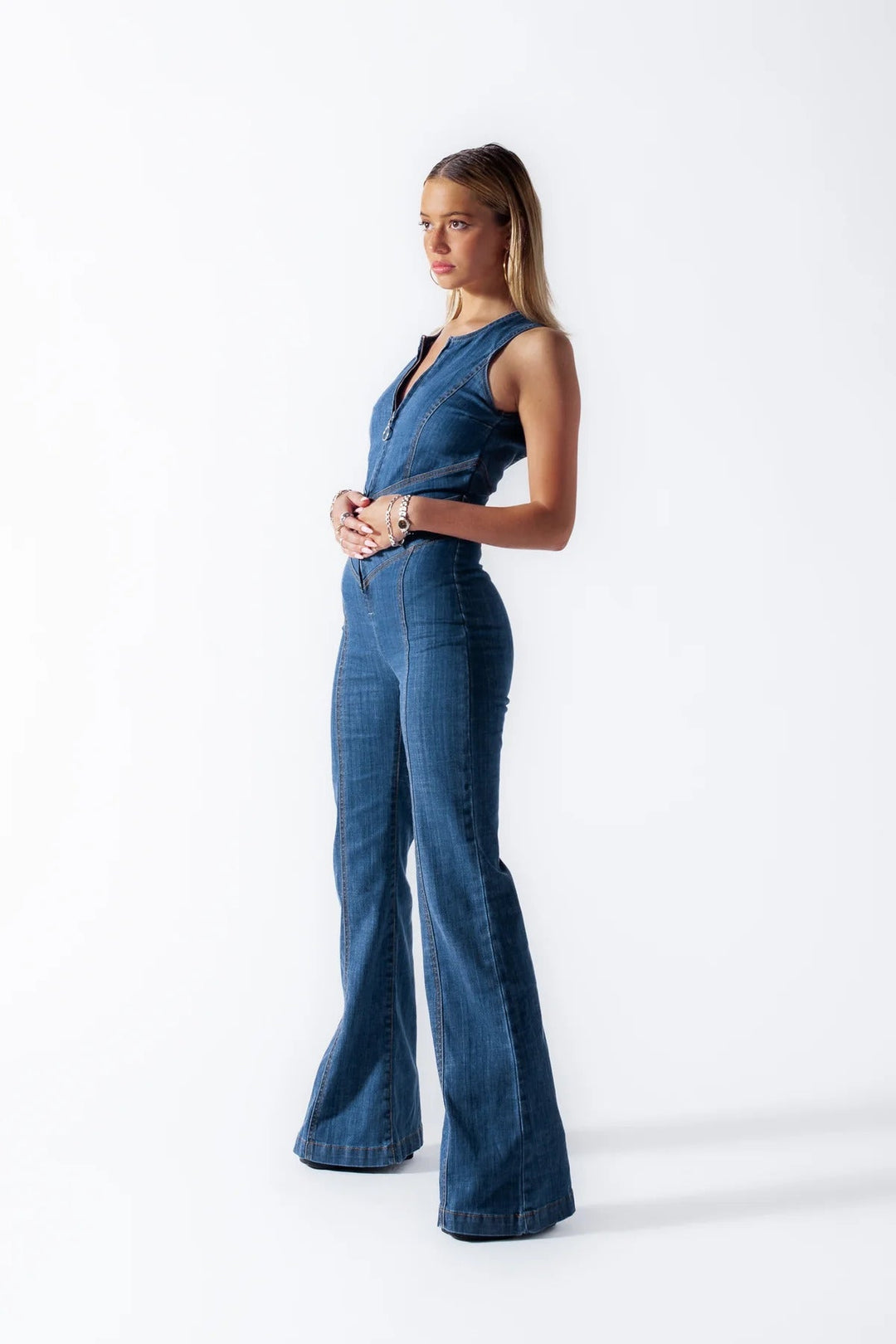 "Dunkelblauer Denim Damen-Overall, ärmellos, mit herzförmigem Rückenausschnitt und Vintage-Charme, vor weißem Hintergrund."