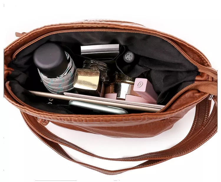 Elegante Damen Umhängetasche aus braunem Leder, robust und stilvoll, mit verstellbaren Riemen und magnetischem Verschluss.