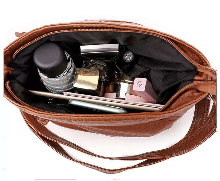 Elegante Damen Umhängetasche aus braunem Leder, robust und stilvoll, mit verstellbaren Riemen und magnetischem Verschluss.