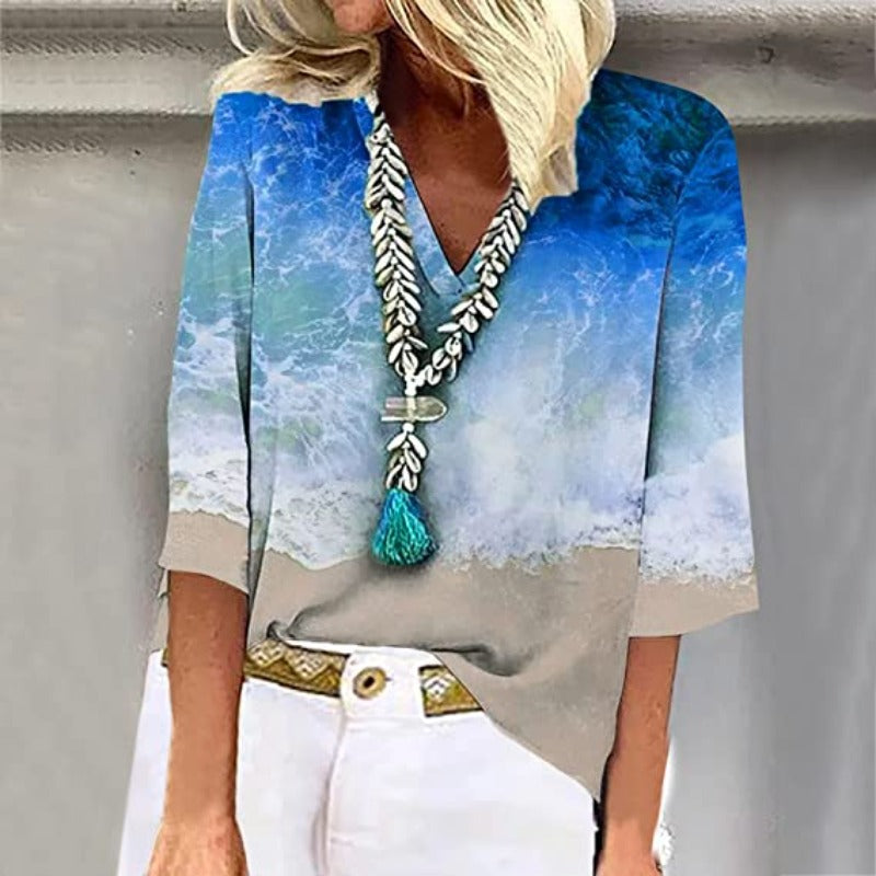 Elegante, luftige Damenbluse mit kristallblauen Nuancen und sandigen Tönen, V-Ausschnitt und weiten Ärmeln.