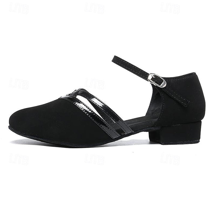 Elegante schwarze Damenschuhe aus Wildleder mit verstellbarem Knöchelriemen, runder Zehenform und niedrigem Absatz.