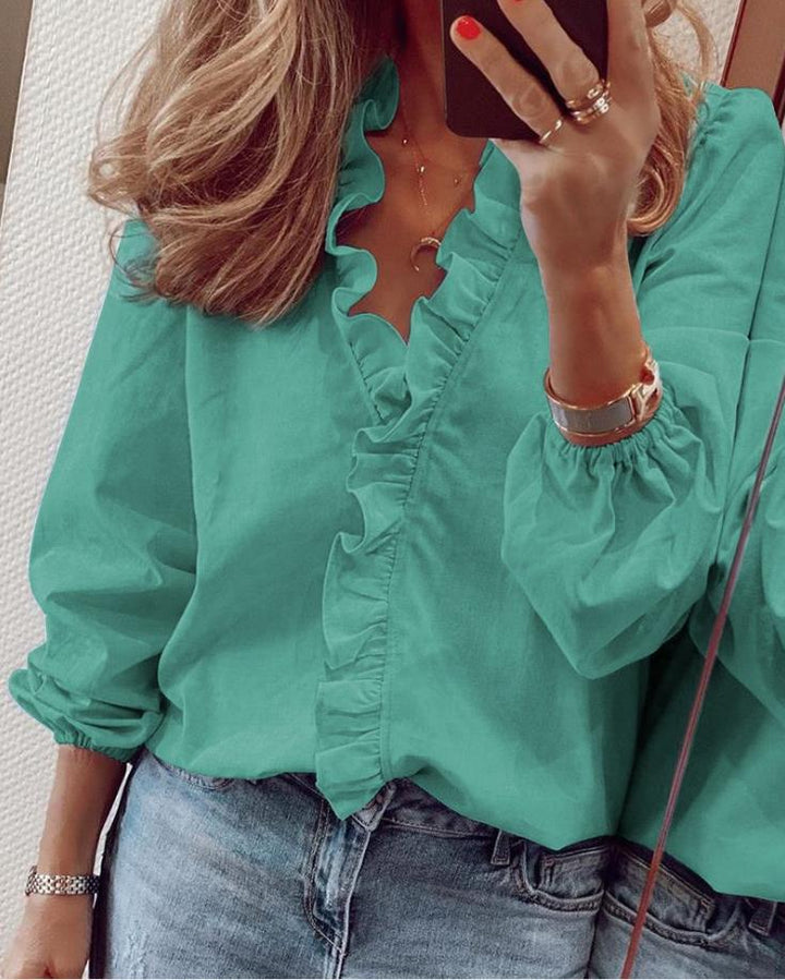 "Elegante V-Ausschnitt Bluse mit zarten Rüschen, feminin und vielseitig für Büro und Freizeit, weicher Stoff in Blau."