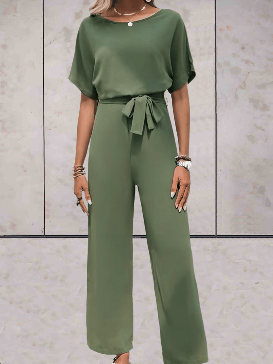Eleganter Jumpsuit in Beige, schwarze Details, betont Silhouette, vielseitig für Tag und Abend, verfügbar in XS-2XL.