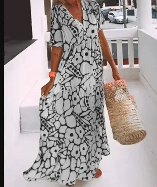 Elegantes Blumenkleid für Damen mit lebendigem Blumenmuster und fließender Silhouette, ideal für sommerliche Anlässe.