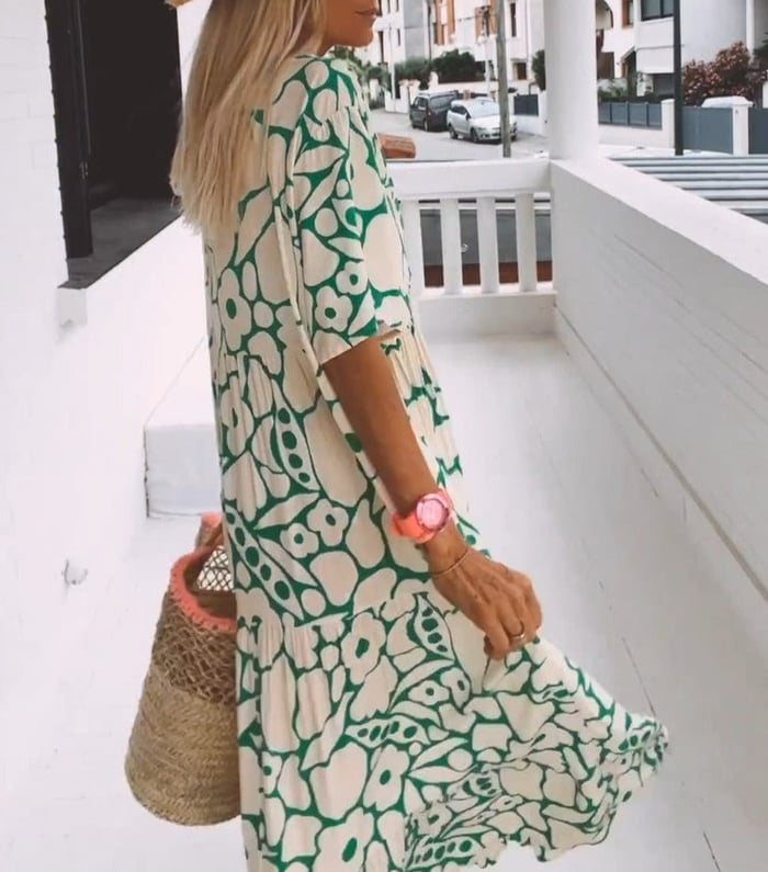 Elegantes Blumenkleid für Damen mit lebendigem Blumenmuster und fließender Silhouette, ideal für sommerliche Anlässe.