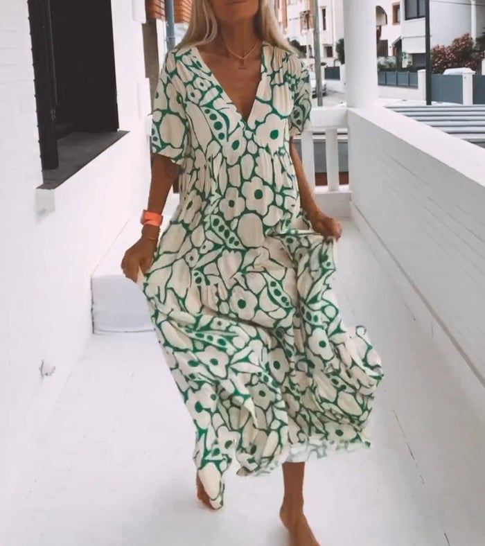 Elegantes Blumenkleid für Damen mit lebendigem Blumenmuster und fließender Silhouette, ideal für sommerliche Anlässe.