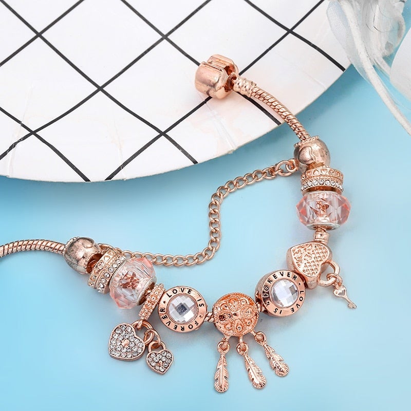 Elegantes Sterling Silber Armband mit rosa Kristallen und Charms in Herzform, handgefertigt, symbolisiert Schutz und Eleganz.