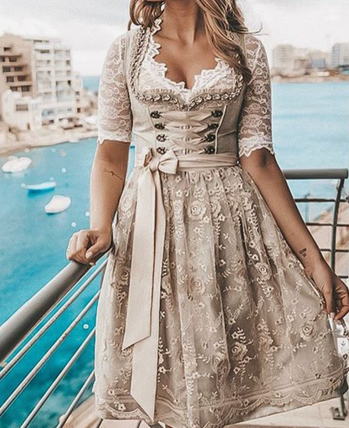 "Elegantes traditionelles Dirndlkleid mit Schnürung, Spitzenbluse und Blumendruck, perfekt für Oktoberfest und Volksfeste."