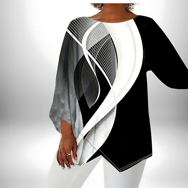 Geometrisches Langarm-Damentop in Schwarz-Weiß, asymmetrischer Saum, vielseitig kombinierbar für elegante und modische Looks.
