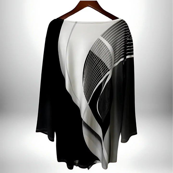 Geometrisches Langarm-Damentop in Schwarz-Weiß, asymmetrischer Saum, vielseitig kombinierbar für elegante und modische Looks.