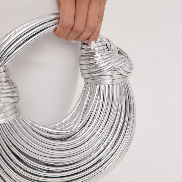 "Goldene geknotete Schultertasche mit eleganten Knotenakzenten, seitliche Ansicht, modernes Damen-Accessoire."