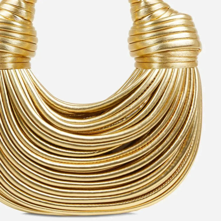 "Goldene geknotete Schultertasche mit eleganten Knotenakzenten, seitliche Ansicht, modernes Damen-Accessoire."