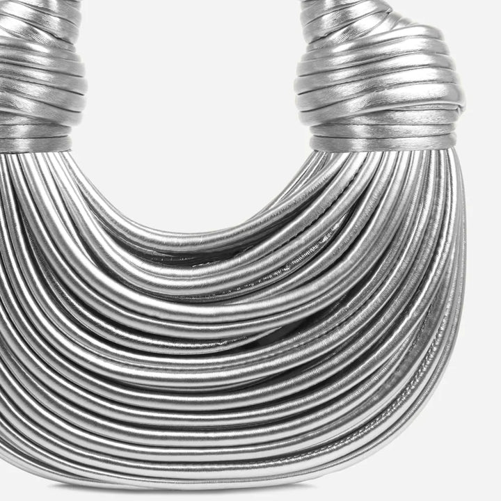 "Goldene geknotete Schultertasche mit eleganten Knotenakzenten, seitliche Ansicht, modernes Damen-Accessoire."