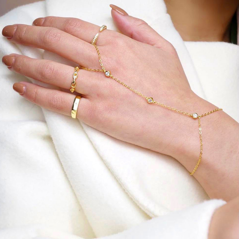 "Goldenes Kettenarmband mit funkelnden Kristallen und integriertem Fingerring aus Edelstahl, elegant und anpassbar."
