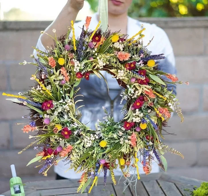 "Handgefertigter Kranz aus Kunstwildblumen mit rustikalem Design, blaue Lupinen und Indianermalpinsel auf Naturhintergrund"