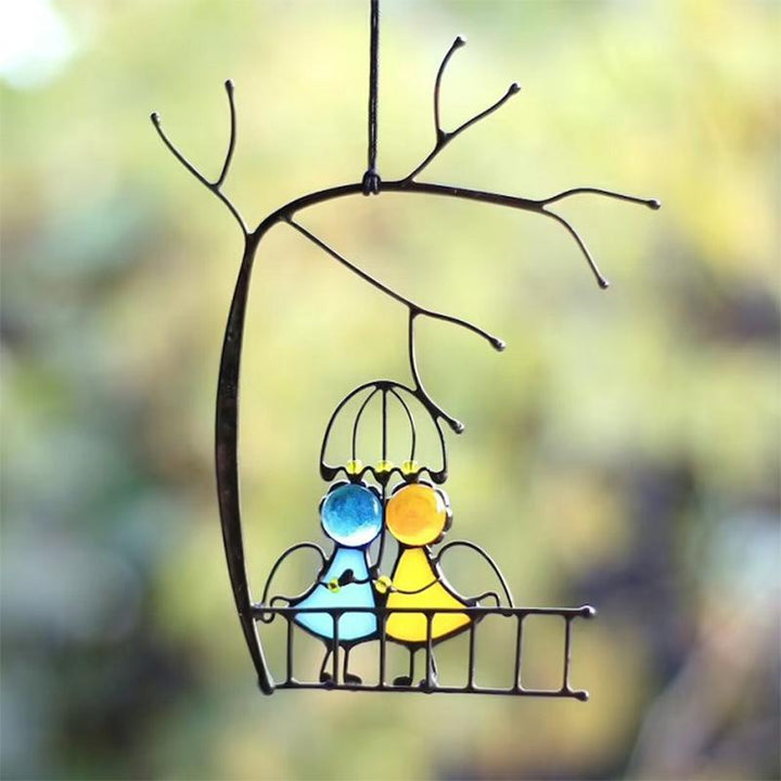 "Handgefertigter Sonnenfänger aus Buntglas mit farbenfrohen, handbemalten Engeln beleuchtet Fenster und Innenräume."