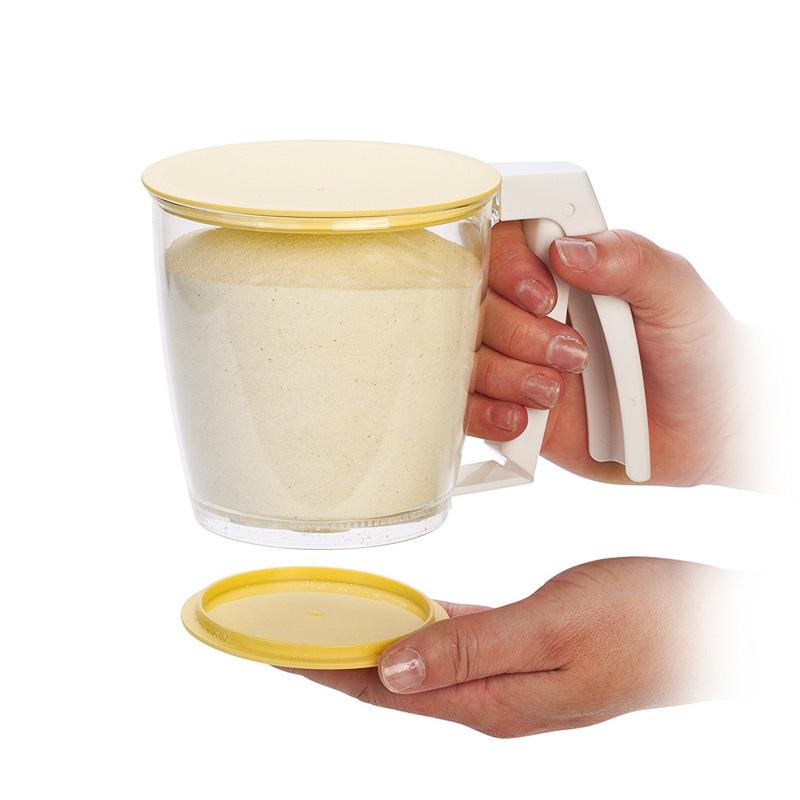 Handgehaltenes gelbes Mehlsieb für einfaches Einhandsieben, aus lebensmittelechtem Material, platzsparend und effizient.