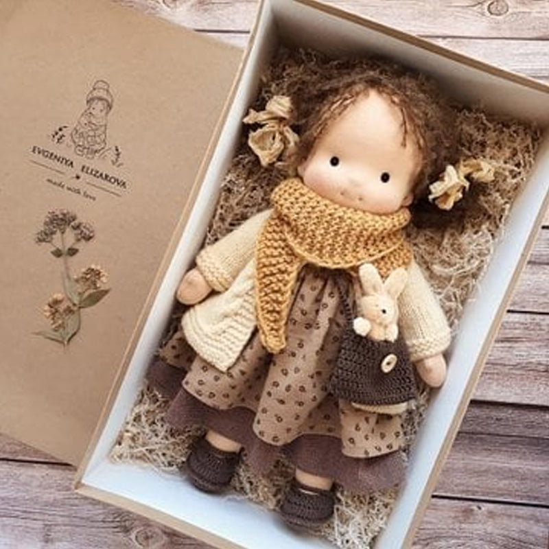 "Handgemachte Waldorfpuppe mit roten Haaren und farbenfrohem Kleid, ideal für kreatives, sicheres Spielen von Kindern."