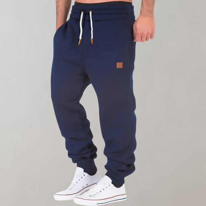 "Herren Jogginghose, bequem mit Baggy-Passform, weiches Material, dunkle Farbe, sportlich und elegant, Seitenansicht"