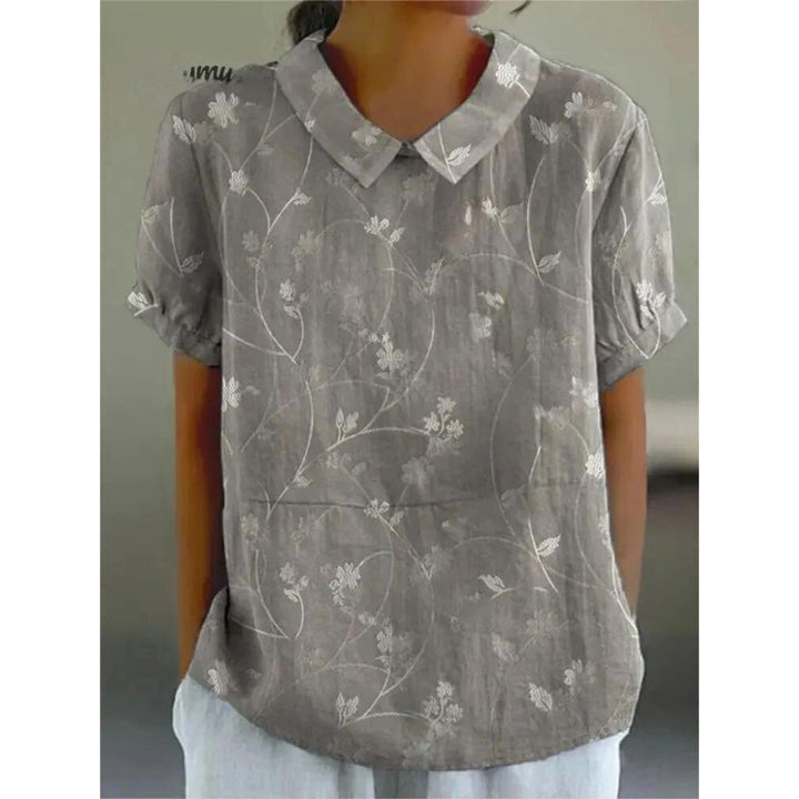 Lässige Damenbluse mit floralem Print, aus leichter Baumwolle, Rundhals und kurzen Ärmeln für sommerliche Tage.