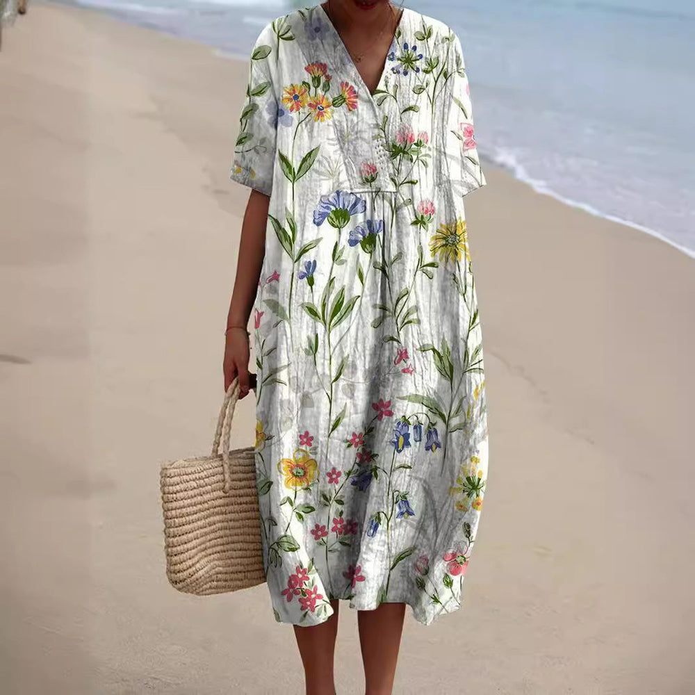 "Lebhaftes Sommerkleid mit V-Ausschnitt und Blumenmuster, ideal für sonnige Tage; locker geschnitten und aus Baumwolle."