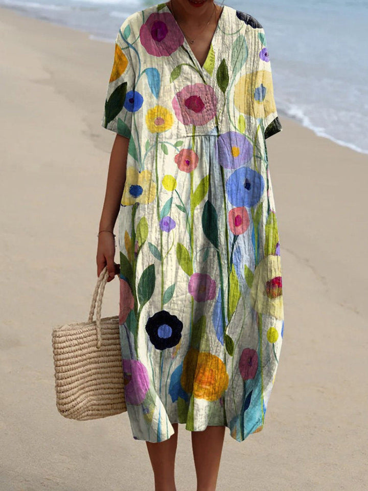 "Lebhaftes Sommerkleid mit V-Ausschnitt und Blumenmuster, ideal für sonnige Tage; locker geschnitten und aus Baumwolle."