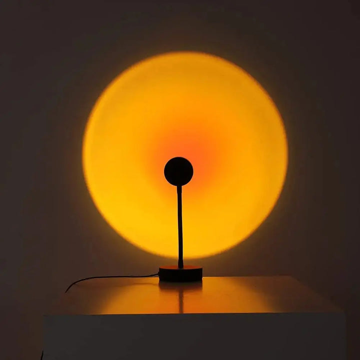 "LED-Projektionslampe mit Sonnenuntergangsfarben, kompakt und modern, schafft stimmungsvolle Beleuchtung auf Tischen"