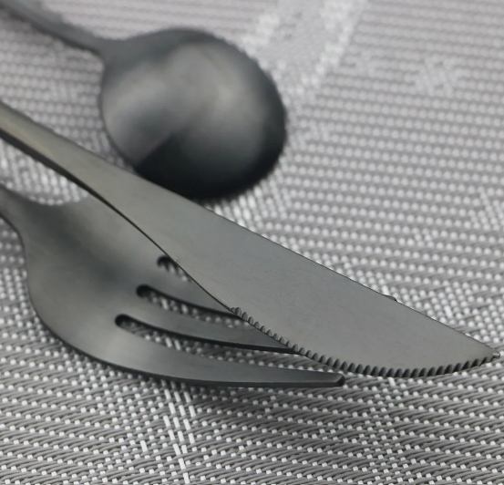 Modernes Besteckset aus Edelstahl in mattem Schwarz, minimalistisches Design, edel, für zeitlose Eleganz am Tisch.