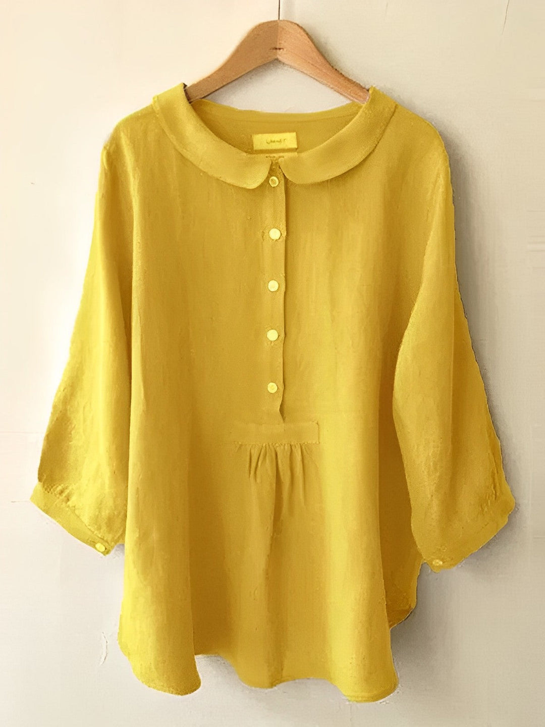 Plisseebluse in Sonnenblumengelb, elegant und modern, mit rundem Ausschnitt, dreiviertel Ärmel, weicher fließender Stoff.