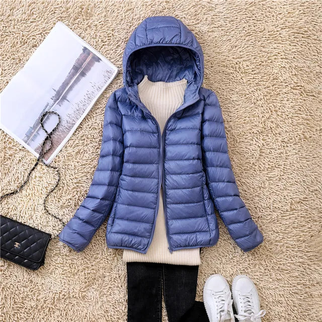 "Rosaroter Daunenmantel mit Kapuze und grauem Innentop, kombiniert mit schwarzen Jeans, für Damenmode."