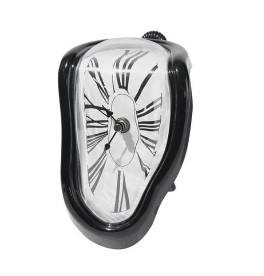 "Schmelzende Dekoruhr, surrealistisches Salvador Dali Design, goldene und schwarze Uhr auf einem Regal"