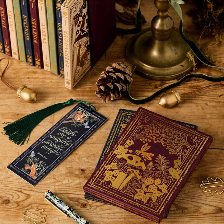 "Schreibwaren-Adventskalender mit Winterwald-Design, 24 Überraschungen, tiefen Beerenfarben, recycelbare Verpackung."