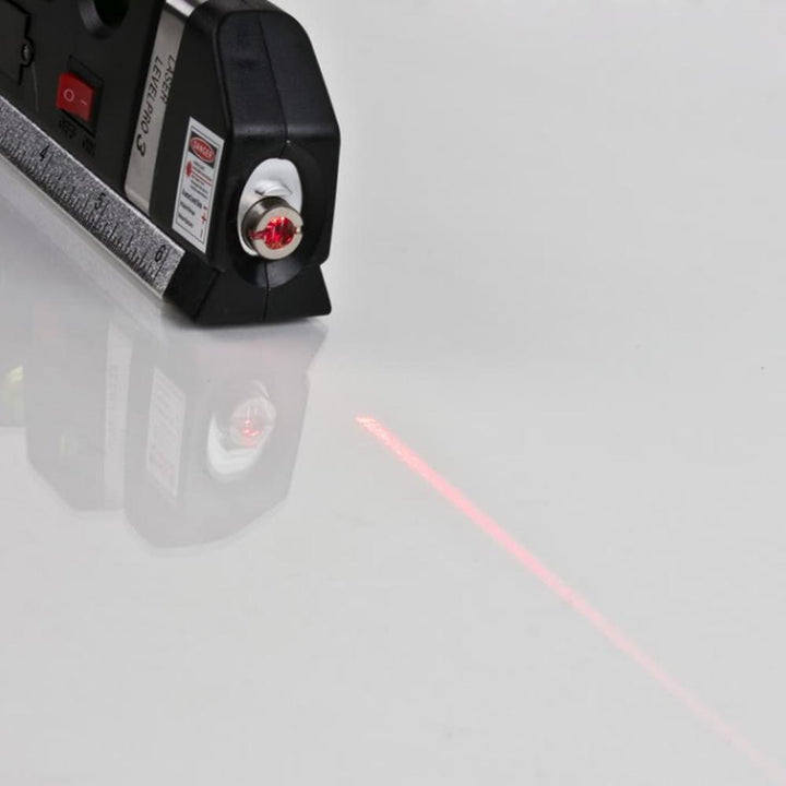 "Schwarze multifunktionale Laser-Wasserwaage mit Maßband, Blasenlibelle und Laserstrahl auf Holzhintergrund."