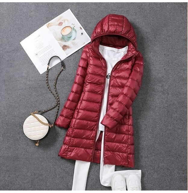 "Ultraleichter, langer Puffermantel für Damen, elegant, grau, optimaler Wärmeschutz, packbar für Reisen, seitliche Ansicht."