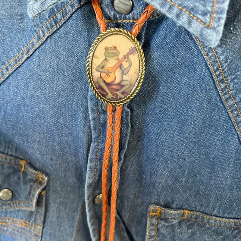 "Unisex Bolo Krawatte mit Banjo Frosch Design; stilvolles Accessoire, verstellbare Lederbänder, moderner Look."