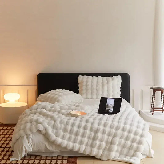 Weiche Plüschwolldecke, kuschelig und stilvoll, in eleganten Farben für gemütliche Abende auf Sofa oder Bett.
