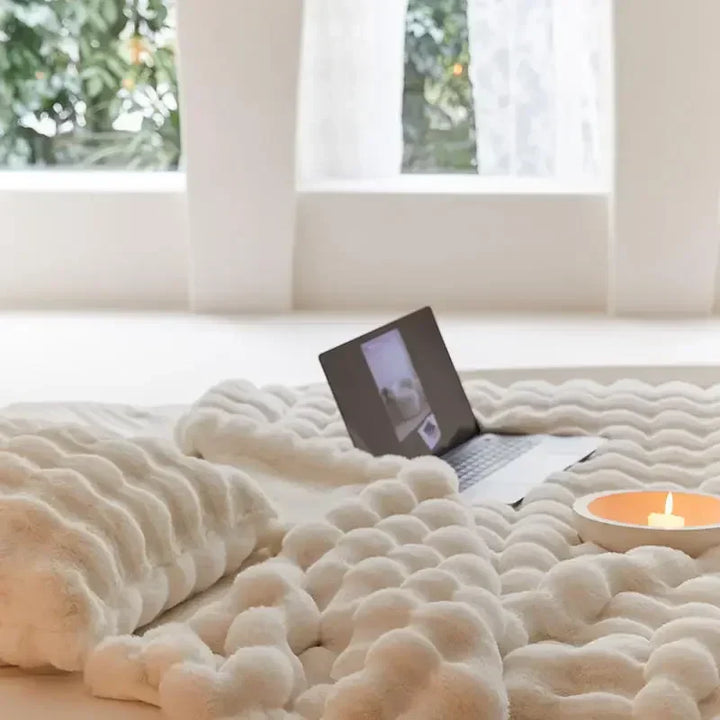 Weiche Plüschwolldecke, kuschelig und stilvoll, in eleganten Farben für gemütliche Abende auf Sofa oder Bett.