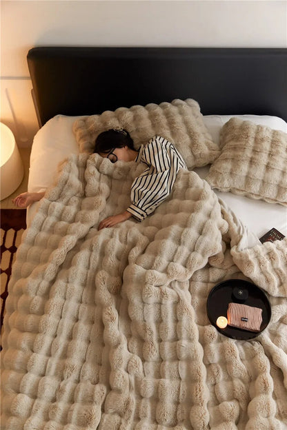 Weiche Plüschwolldecke, kuschelig und stilvoll, in eleganten Farben für gemütliche Abende auf Sofa oder Bett.